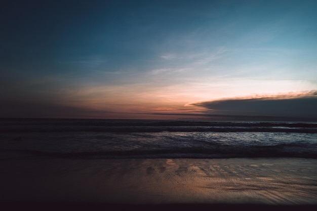 Incroyable coucher de soleil ciel bleu foncé sur l'océan Indien avec des vagues sur l'île de Bali fond d'écran