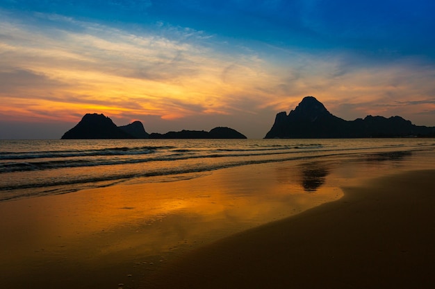 Incroyable coucher de soleil sur la plage avec un horizon sans fin et des personnages solitaires au loin et une mousse incroyable