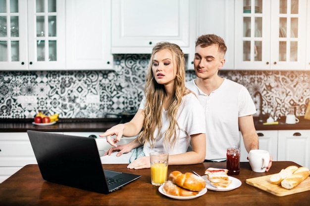 Incroyable couple utilisant un ordinateur portable ensemble dans