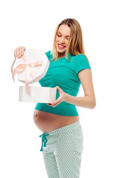 Incroyable femme enceinte tenant une boîte avec un arc un cadeau, ouvre le cadeau, des émotions heureuses.