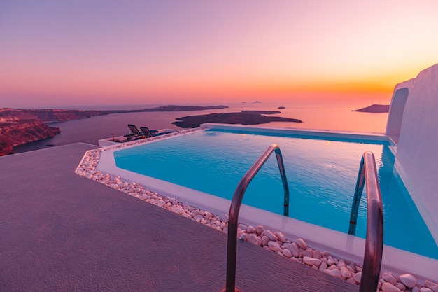 Incroyable paysage de soirée de la piscine à débordement d'Oia vue sur la caldeira Santorin Grèce Hôtel de voyage de luxe