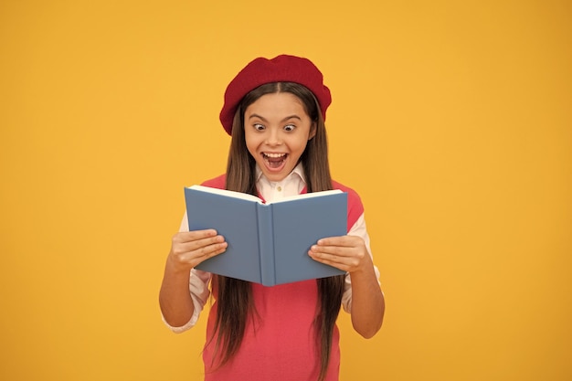 Incroyable retour à l'école enfant surpris en béret prêt à étudier un livre de lecture d'enfant étonné