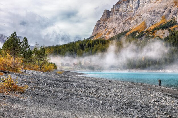 Photo incroyable vue d'automne sur le lac d'oeschinensee scène des alpes suisses avec le sommet de bluemlisalp en arrière-plan emplacement vallée d'oeschinen canton de berne suisse europe