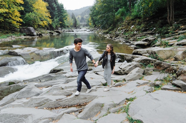 incroyablement beau et charmant couple près d'une rivière de montagne