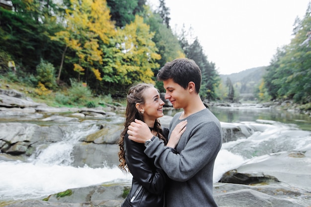 incroyablement beau et charmant couple près d'une rivière de montagne