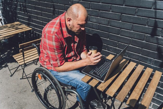 Indépendant avec un handicap physique qui utilise un fauteuil roulant travaillant au café de la rue