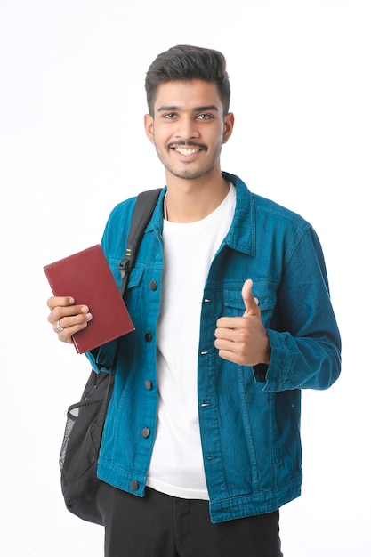 Indian college boy montrant le journal sur fond blanc.