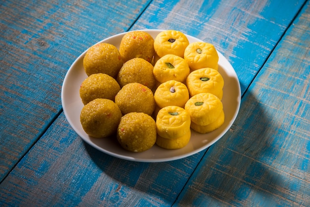 Indian Festival Sweets Bundi ou Motichur Laddu et Kesar Pedha ou Pera servis dans une assiette ensemble sur fond de mauvaise humeur. mise au point sélective