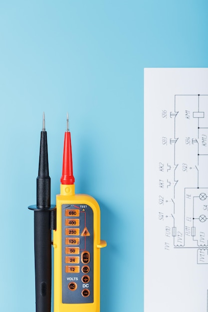 Indicateur de tension bipolaire avec schémas électriques sur fond bleu. Test et vérification des réseaux électriques