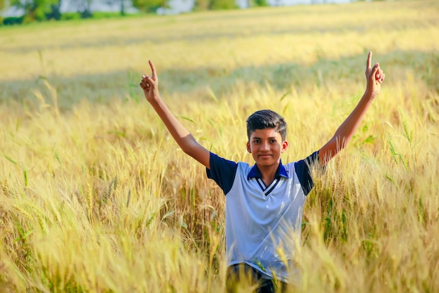 Indien / asiatique petit garçon jouant dans le champ de blé