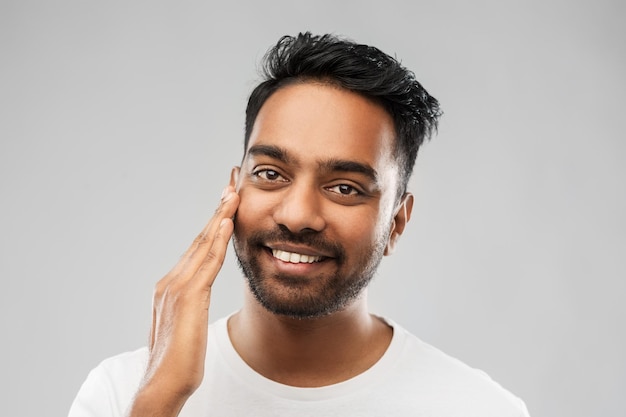 Photo un indien souriant qui lui touche le visage.