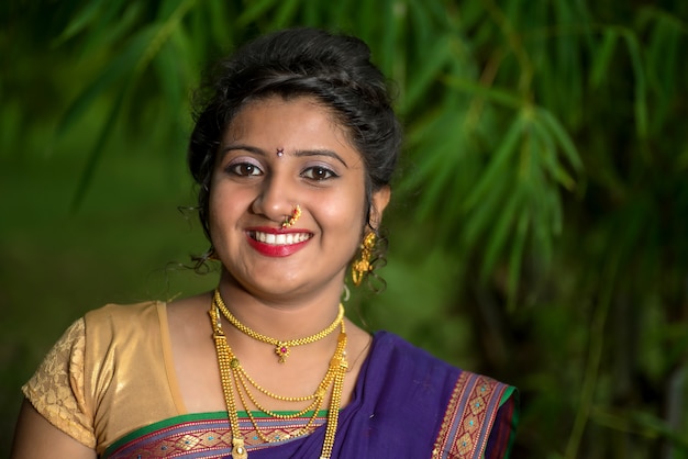 Indien traditionnel belle jeune femme en saree posant à l'extérieur