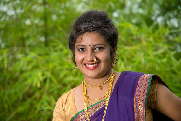 Indien traditionnel belle jeune fille en saree posant à l'extérieur