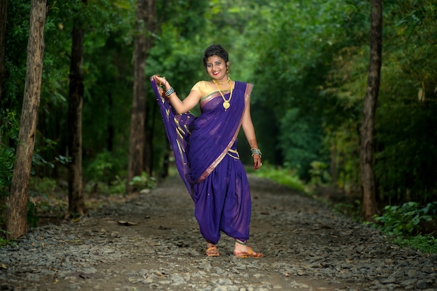 Indien traditionnel belle jeune fille en saree posant à l'extérieur