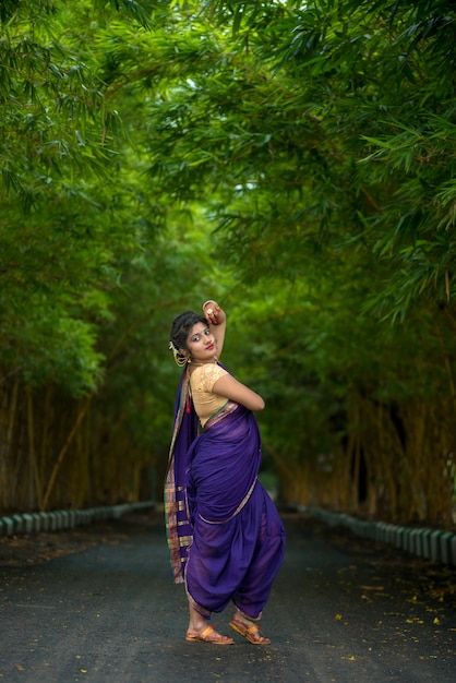 Indien traditionnel belle jeune fille en saree posant à l'extérieur