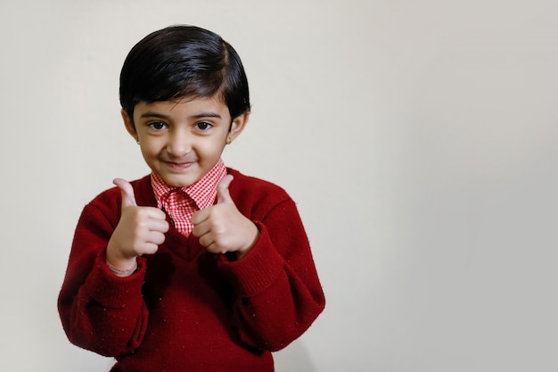 Indienne petite fille en uniforme scolaire et montrant des coups