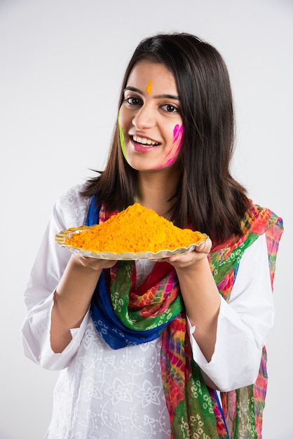 Indiens célébrant holi avec du laddu sucré, des couleurs en thali et des éclaboussures de couleurs