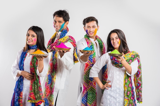 Indiens célébrant holi avec du laddu sucré, des couleurs en thali et des éclaboussures de couleurs