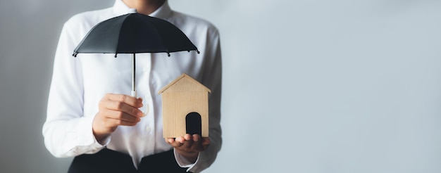 Photo individus détenant de petits parapluies et des maisons modèles assurance logement contre les pertes et incendies imminents assurance incendie construction concepts d'assurance habitation et immobilier