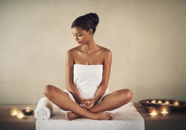 L'indulgence du spa Photo pleine longueur d'une jeune femme assise sur une table de massage au spa