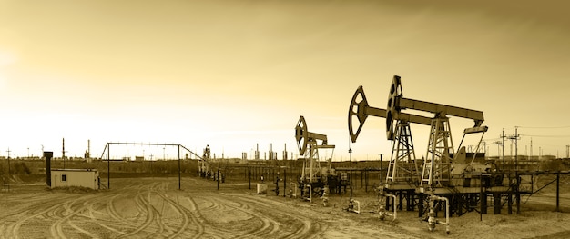 Industrie du pétrole et du gaz. Panoramique d'un pumpjack et d'une raffinerie de pétrole.