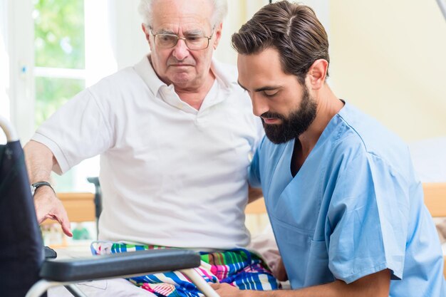 Photo infirmière aidant un patient âgé dans une maison de retraite