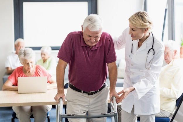 Infirmière aidant senior avec aide à la marche