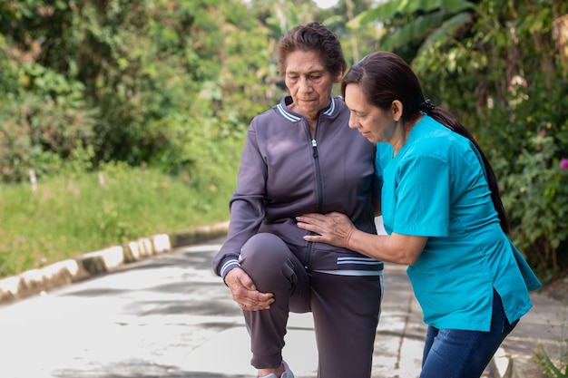 Une infirmière aide une femme âgée à rester active et en bonne santé avec des étirements de physiothérapie en plein air