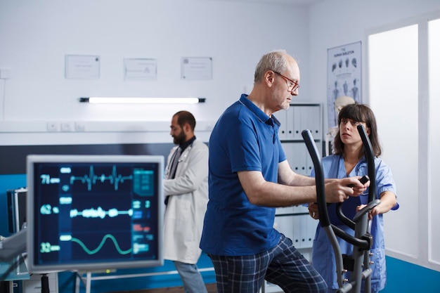 L'infirmière aide le vieil homme à la physiothérapie.