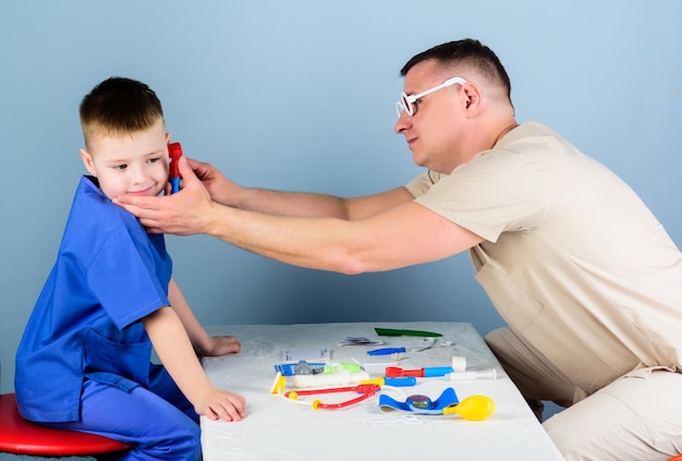 Infirmière assistante de laboratoire médecin de famille petit garçon avec papa jouer Future carrière enfant heureux avec père avec stéthoscope médecine et santé père et fils en uniforme médical infirmière et médecin