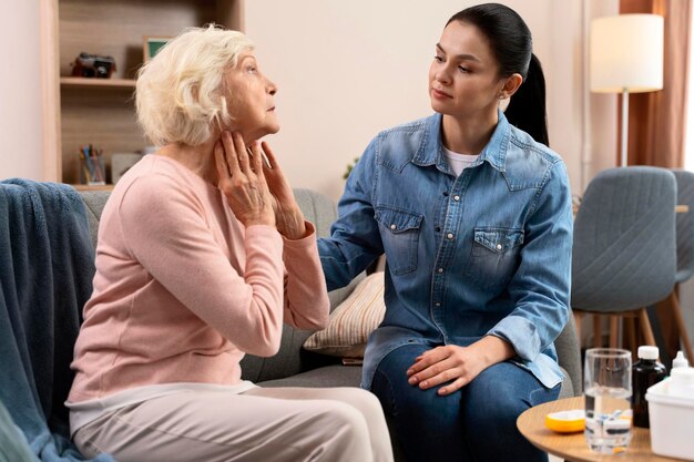 Infirmière attentionnée examinant une femme âgée malade à la maison Prendre soin du concept de personnes âgées Photo stock