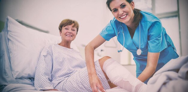 Photo infirmière bandant la jambe du patient