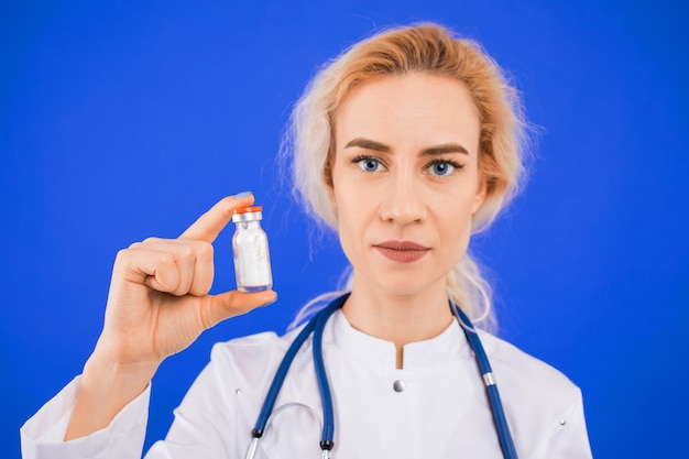 Infirmière avec une bouteille de poudre blanche sur fond bleu