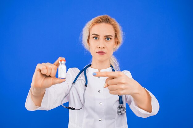 Infirmière avec une bouteille de poudre blanche sur fond bleu