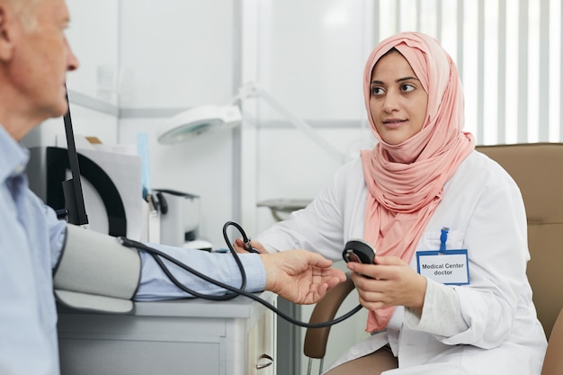 Infirmière du Moyen-Orient examinant un patient âgé