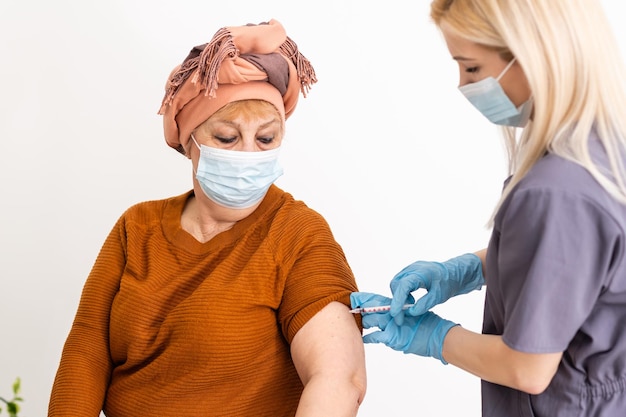 Infirmière faisant une injection de vaccin à un patient âgé.