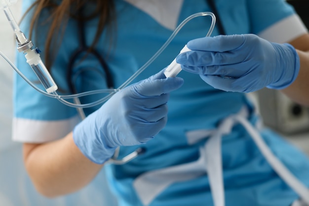 Infirmière en gants de protection bleus détient compte-gouttes