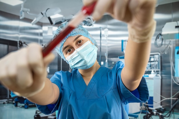 Infirmière à l'hôpital tenant du sang dans des tubes à essai pour analyse Travail au laboratoire clinique