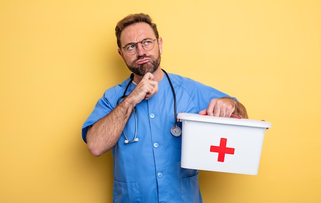 Infirmière ou médecin pensant, se sentant douteuse et confuse. concept d'entreprise et de téléphone. concept de trousse de premiers soins