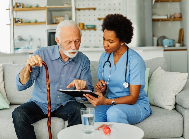 Infirmière médecin soins aux personnes âgées soignant aide assistance maison de retraite soins infirmiers personnes âgées femme homme santé soutien afro-américain noir canne de marche