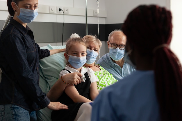 Infirmière noire vérifiant un patient âgé expliquant le traitement de la maladie