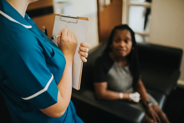 Infirmière Notant L'information D'un Patient