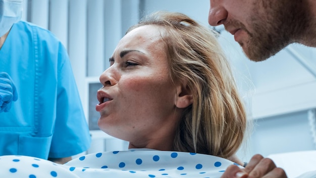 Une infirmière parle à une femme dans un lit d'hôpital.