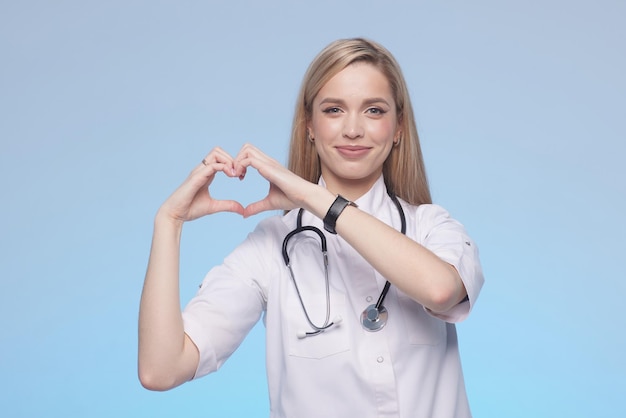 Une infirmière professionnelle démontrant la forme de ses mains en forme de coeur Soins médicaux d'amour