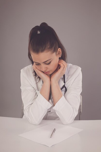 L'infirmière qui rêve est à la table avec des papiers