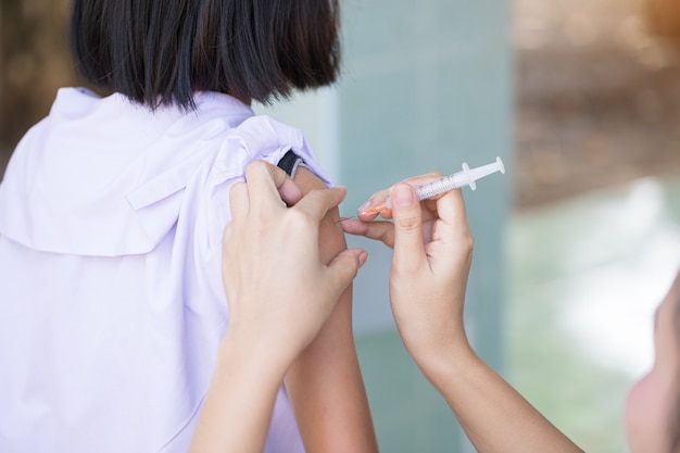 Photo l’infirmière s’injecte un antitétanique à l’intention des filles de l’école primaire en thaïlande.