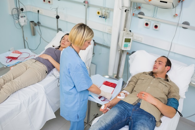 Infirmière soignant un patient transfusé