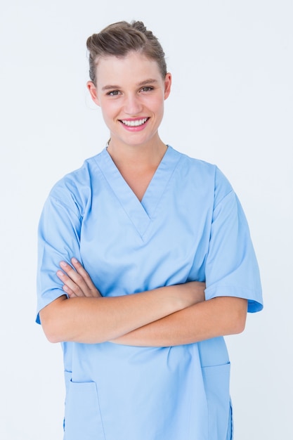 Infirmière souriante en blouses bleues posant avec les bras croisés