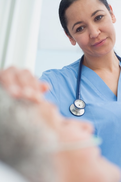 Infirmière souriante regardant un patient