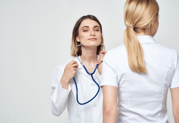 Infirmière en stéthoscope de blouse médicale et vue arrière du patient